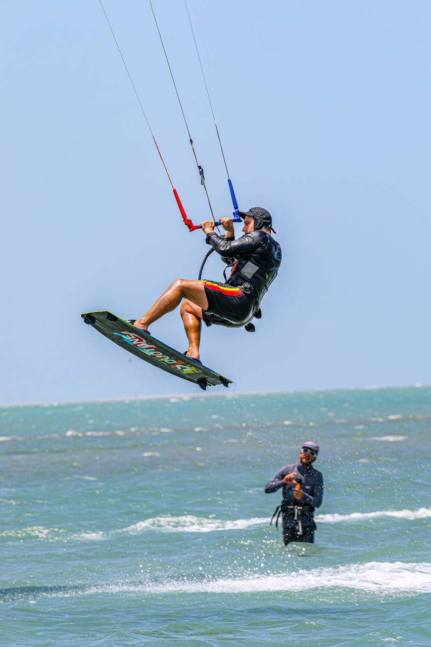 Aluno saltando enquanto instrutor observa no mar